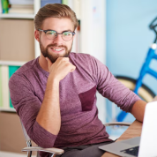 Smiling man with glasses at a desk in an office